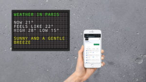 Splitflap tv on a wall being updated from your cell phone or computer