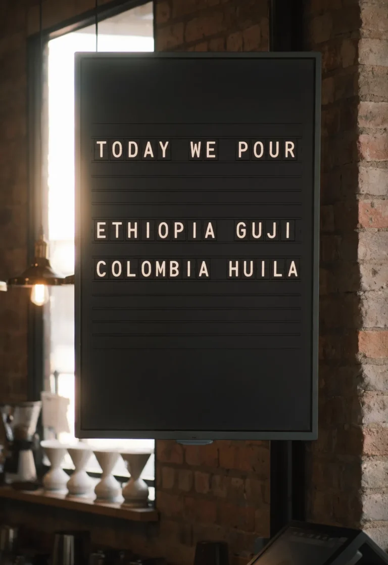 A portrait television in a speciality coffee bar showing a split-flap style board of today's filter coffees.